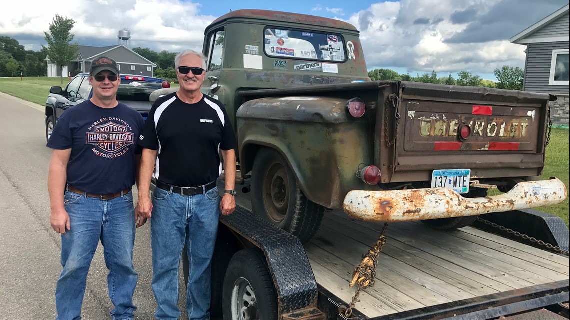 men standing by old pickup truck