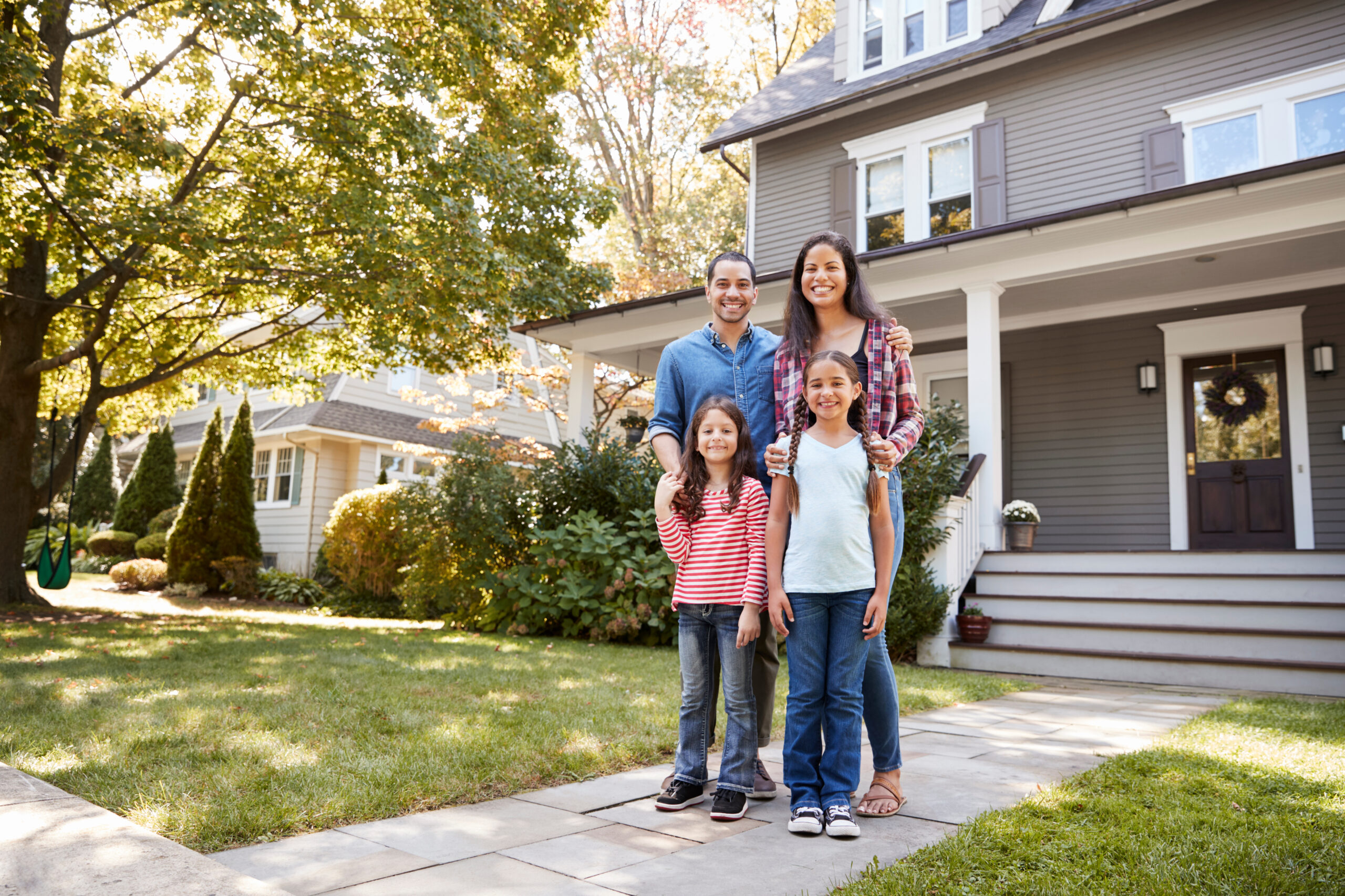 family standing in front of house